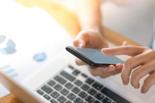 business-woman-hand-with-financial-charts-mobile-phone-laptop-table (1)